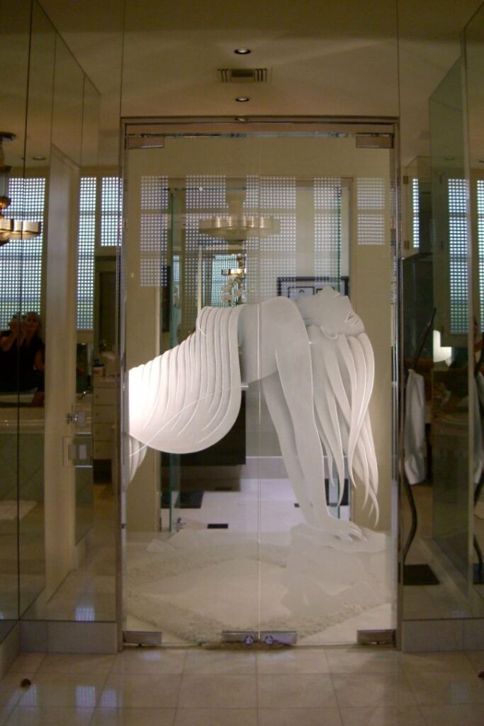 Frameless interior glass double doors with sculpted frosted flowing ribbon design used as a living room divider in a modern luxury home