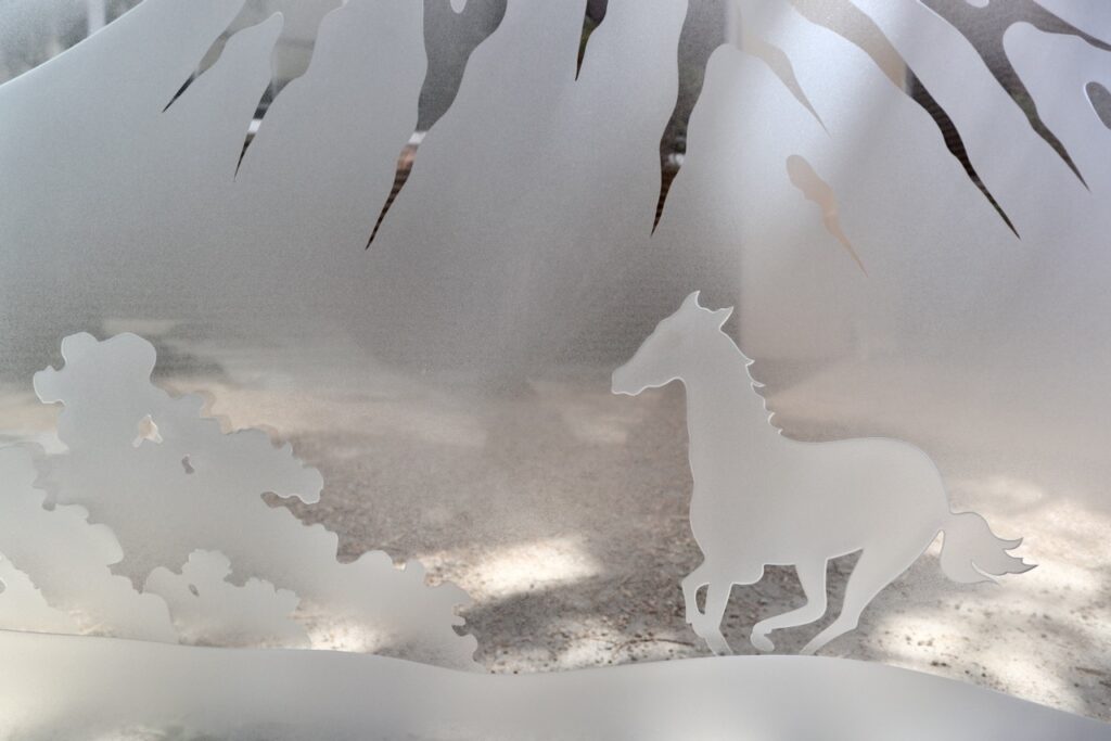 Close-up of etched glass horse design with mountain backdrop highlights intricate sandblasted detail and frosted privacy glass effect