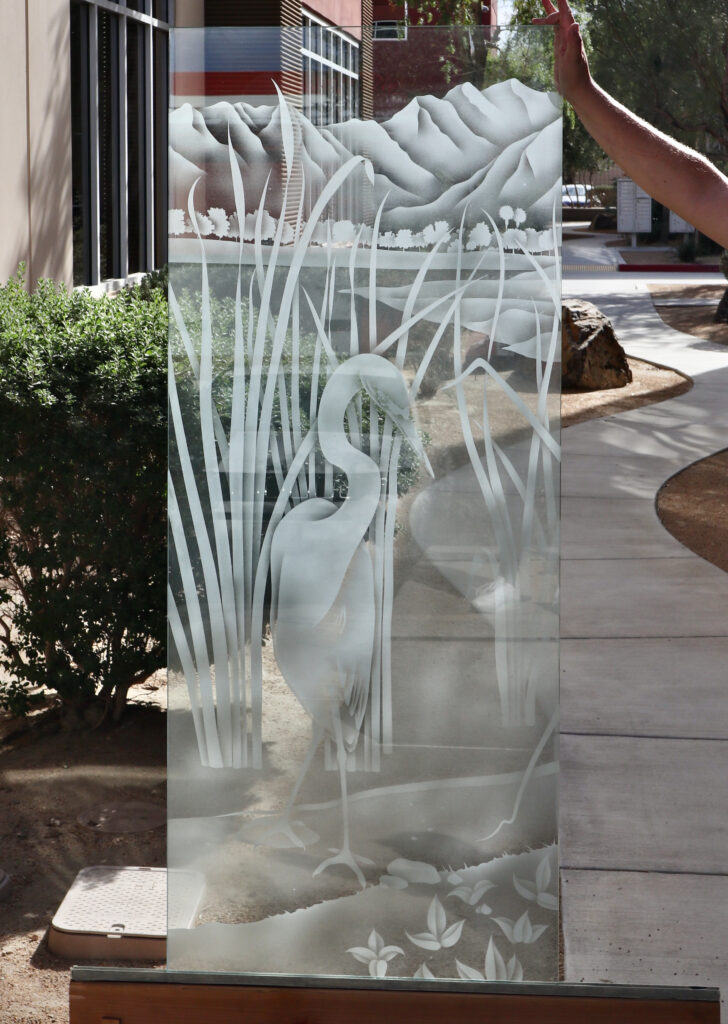 Egret glass partition panel featuring a graceful egret among marsh reeds with distant mountains, rendered in custom frosted glass for privacy and natural beauty.