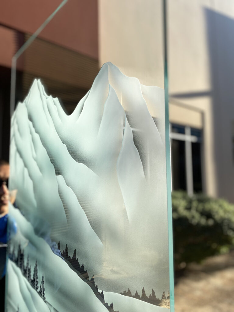 Close-up of the Pine Falls glass partition panel design showcasing dramatic 3D carved peaks, layered alpine terrain, and handcrafted frosted glass artistry with exceptional depth and dimension.