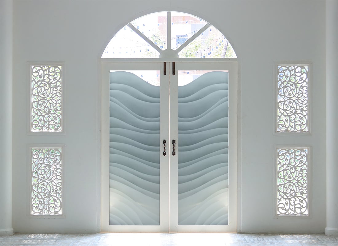 Custom glass front doors with transom windows, handcrafted to enhance curb appeal and natural light.