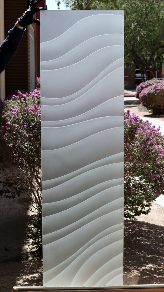 Contemporary glass front doors panel with flowing frosted wave patterns, showing sleek glass door options for a modern entry.