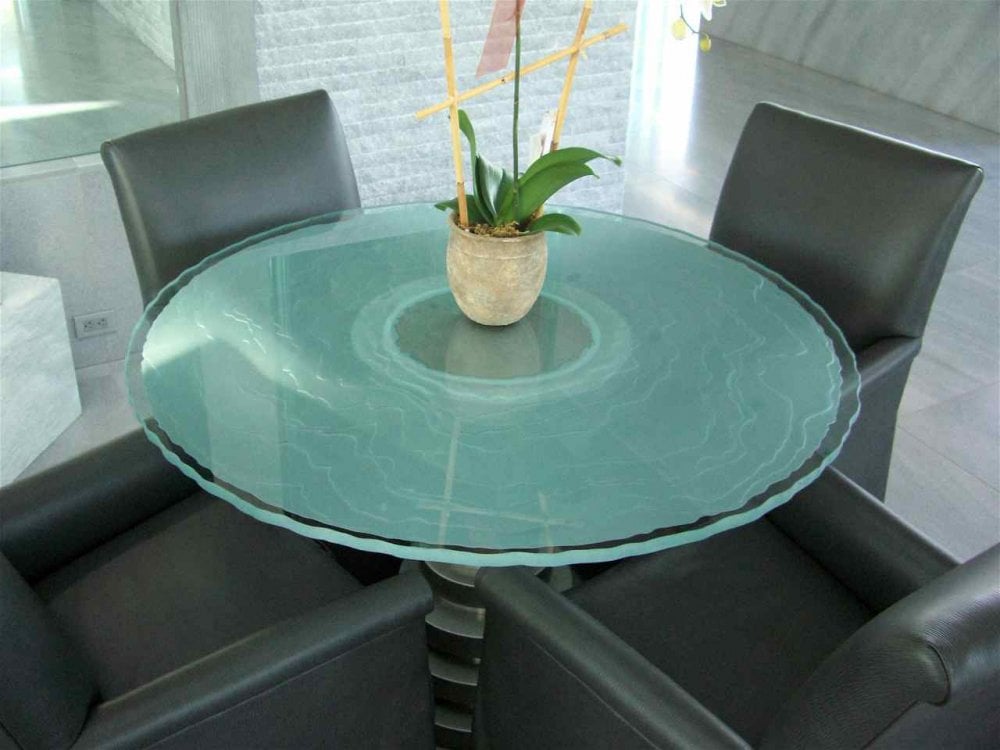 Circle glass table top with 3D carved and shaded custom glass design.
