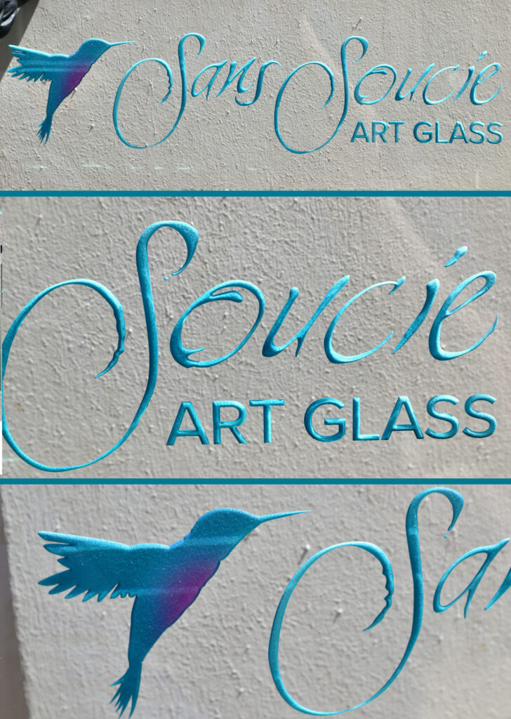 Decorative glass sign with Sans Soucie Art Glass logo and hummingbird, custom painted and etched glass branding signage