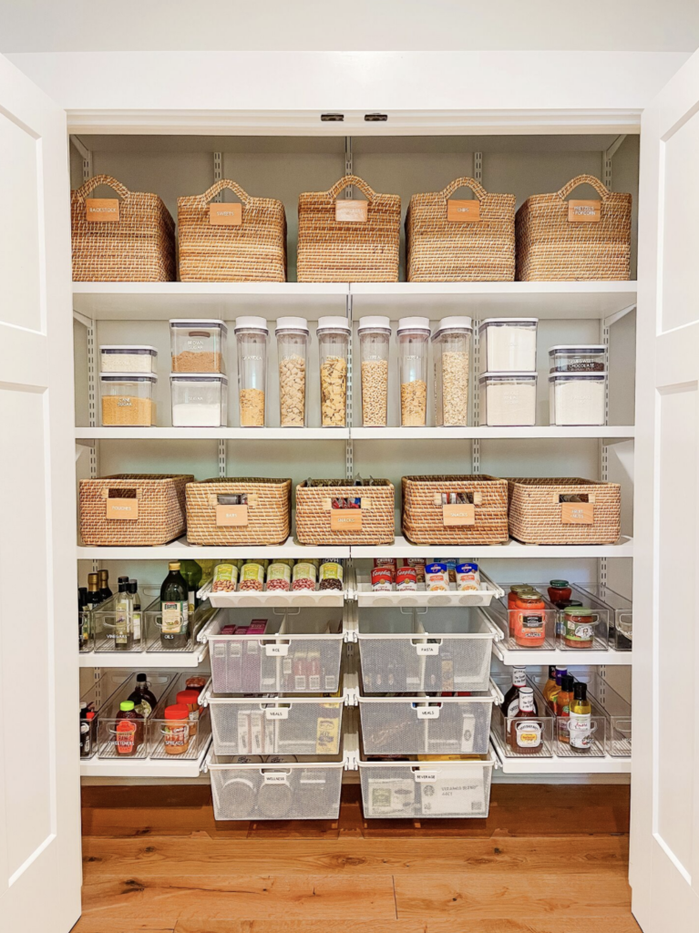 well-organized pantry with acrylic organizers and woven baskets 