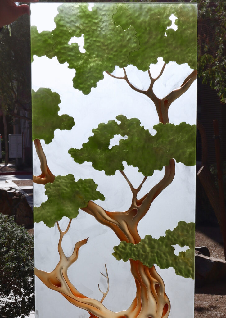 Detailed view of sculpted and painted frosted glass artwork , ideal for a contemporary black front door that blends natural elements with modern design.