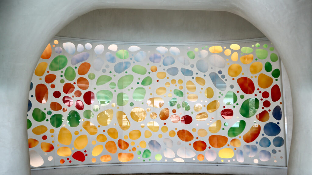 colorful carved and painted glass wall art panel with abstract pebble design in vibrant tones