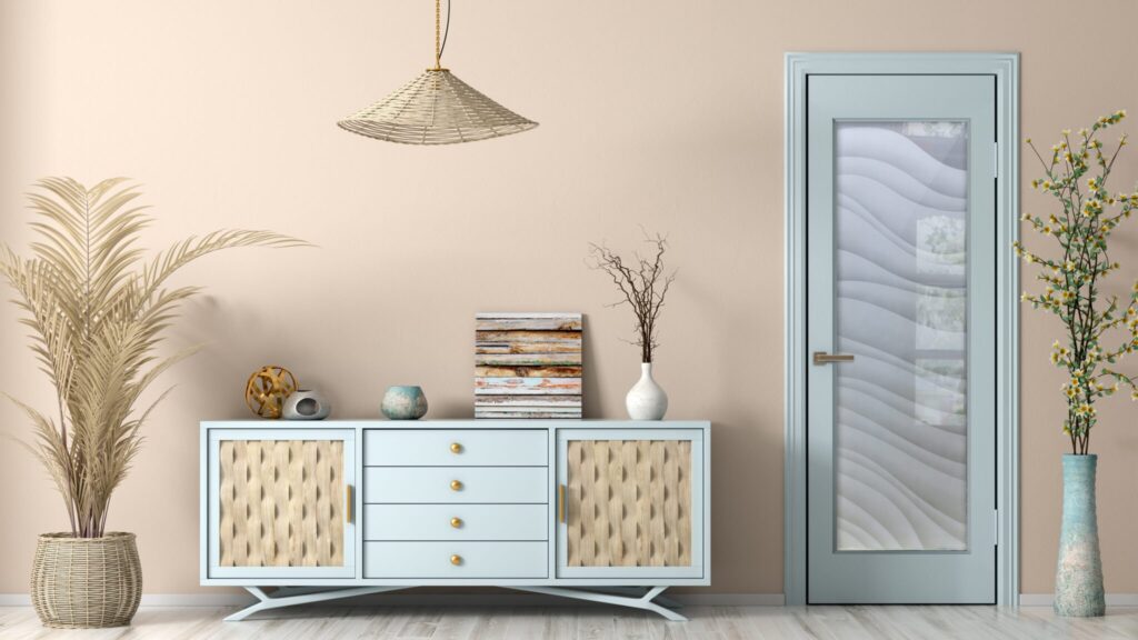 Light blue frosted glass interior door with hand-etched wavy design, 100% private 2D sandblast effect, shown in a modern coastal-style room with beige walls and decorative vase with yellow flowers