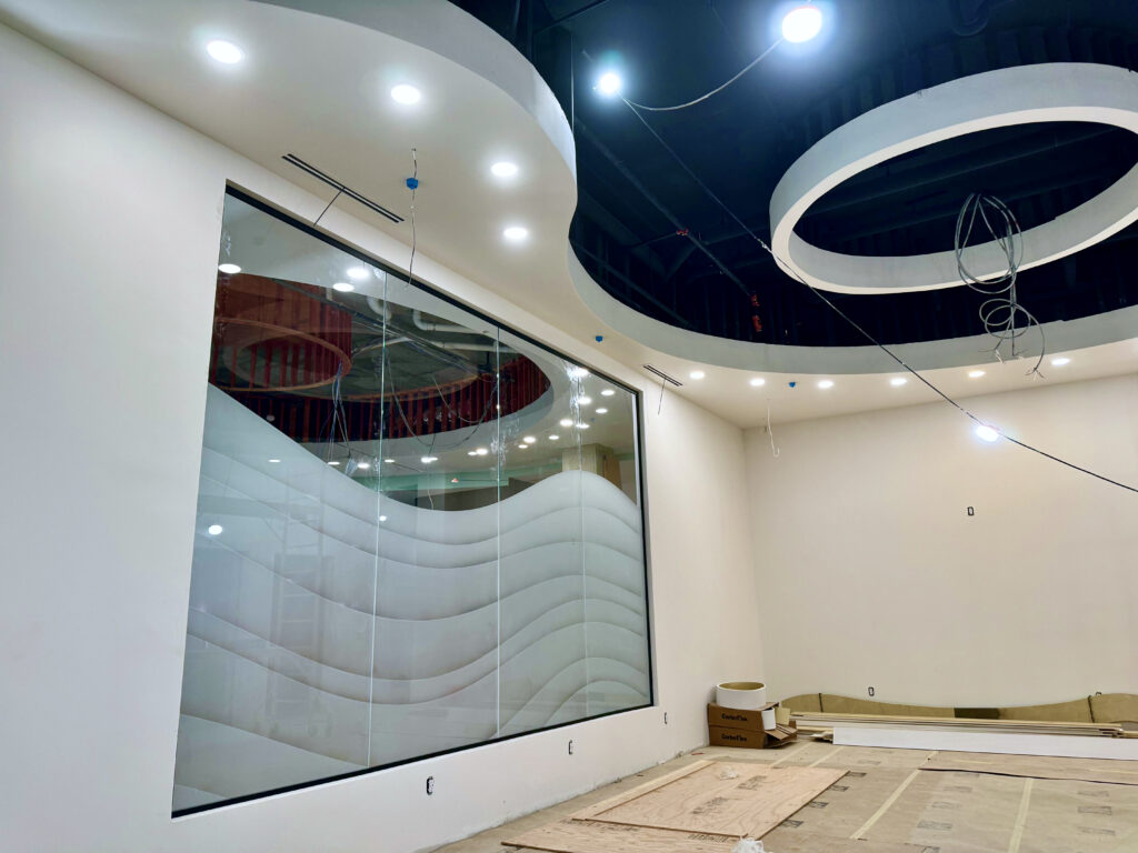 Etched glass panel with layered carved wave pattern and semi-privacy frosting