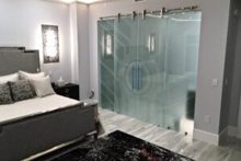 Best glass barn doors for master bathroom featuring double frosted glass panels with a Sun Odyssey design, offering full privacy and a modern, artistic look.