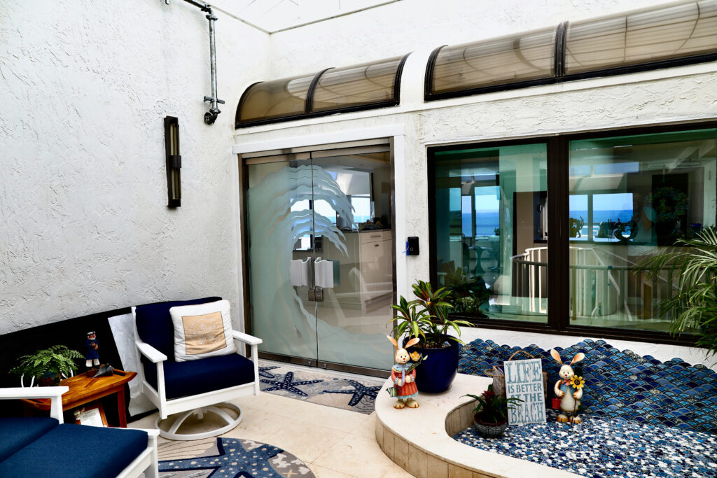 Decorative glass doors with ocean wave design in coastal beach home