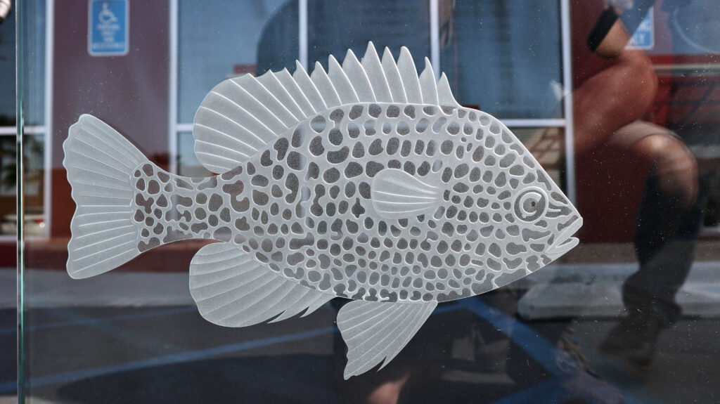 Close-up of precision-carved frosted glass fish artwork
