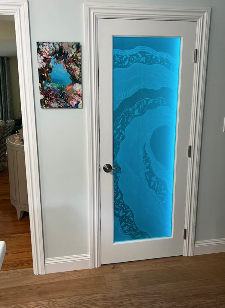 closed interior door featuring illuminated 3D carved glass with flowing wave pattern and blue backlighting