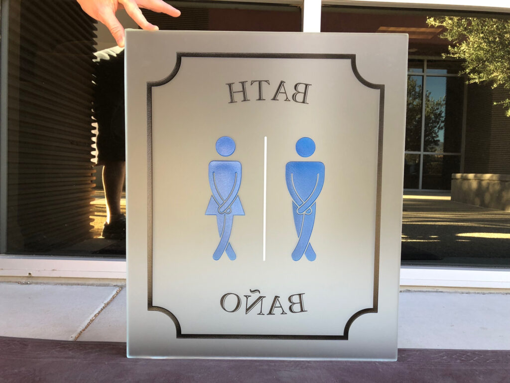 Decorative frosted glass bathroom sign with male and female icons, custom privacy glass signage for restroom identification
