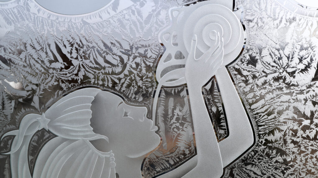Detail view of decorative glass partition design showing etched foliage texture and sculpted mermaid artwork