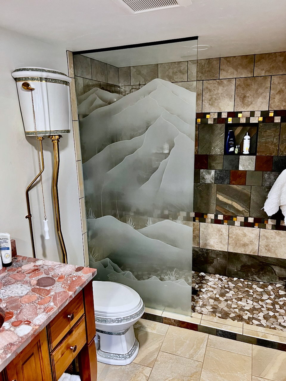 Custom mountain glass shower partition panel with layered mountain ranges and frosted glass privacy design in a luxury bathroom enclosure.