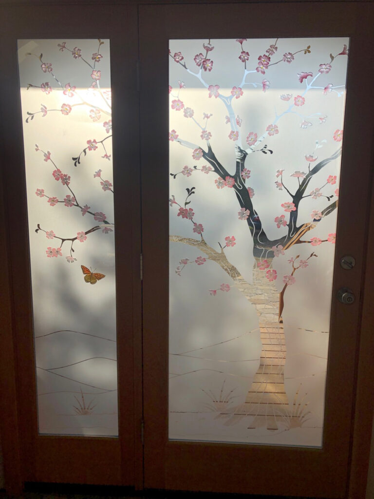 Interior view of the 1D negative frosted glass entry doors with painted cherry blossom design in soft indoor daylight with gentle light filtering through glass