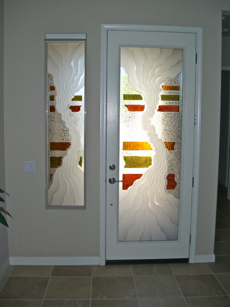 Front door with privacy glass and sidelight featuring abstract etched waves, textured glass, and warm colored glass accents.