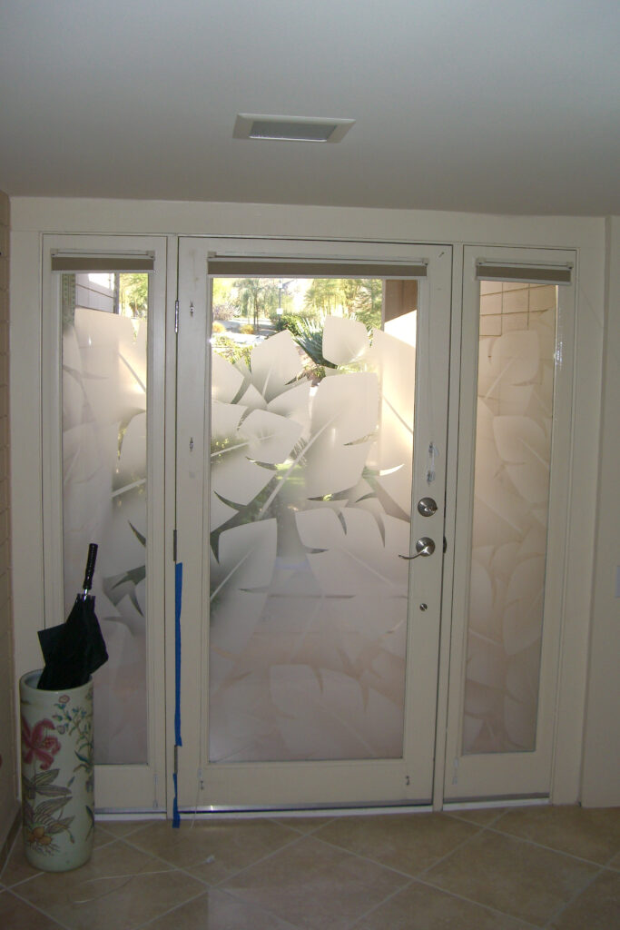 frosted carved glass front door with sidelights featuring abstract tropical leaf design for privacy and natural light