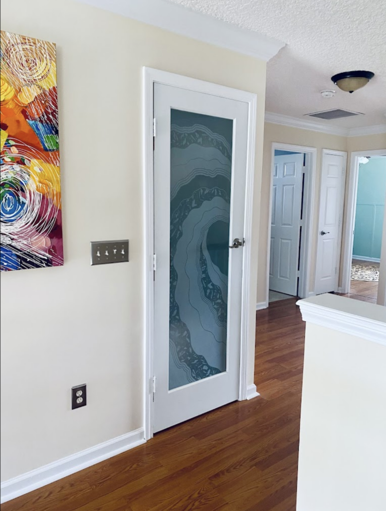 Etched glass front door with layered wave-pattern frosted glass, inspiring contemporary door art ideas for entryways.