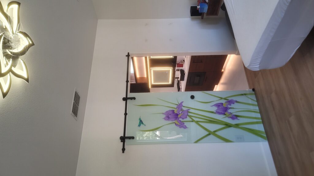 Decorative frosted glass barn door with iris flowers and hummingbird design, featuring hand-painted and frosted etched glass artwork