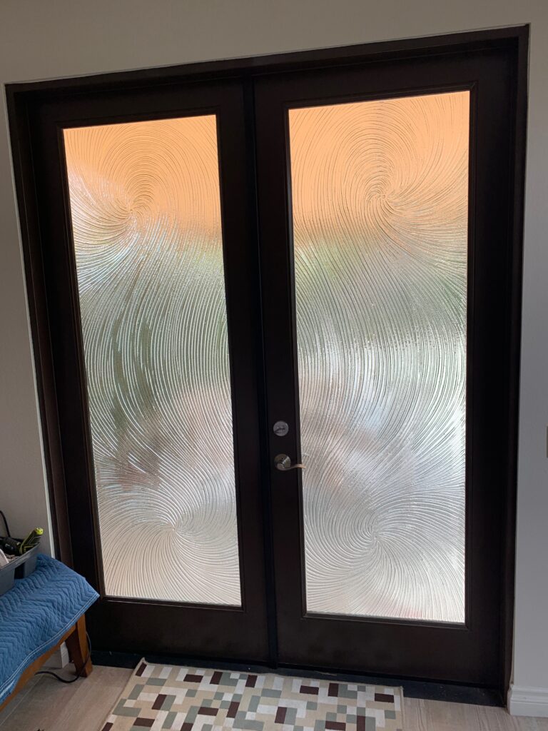 Pair of textured glass front doors with swirling pattern providing high privacy while allowing diffused natural light