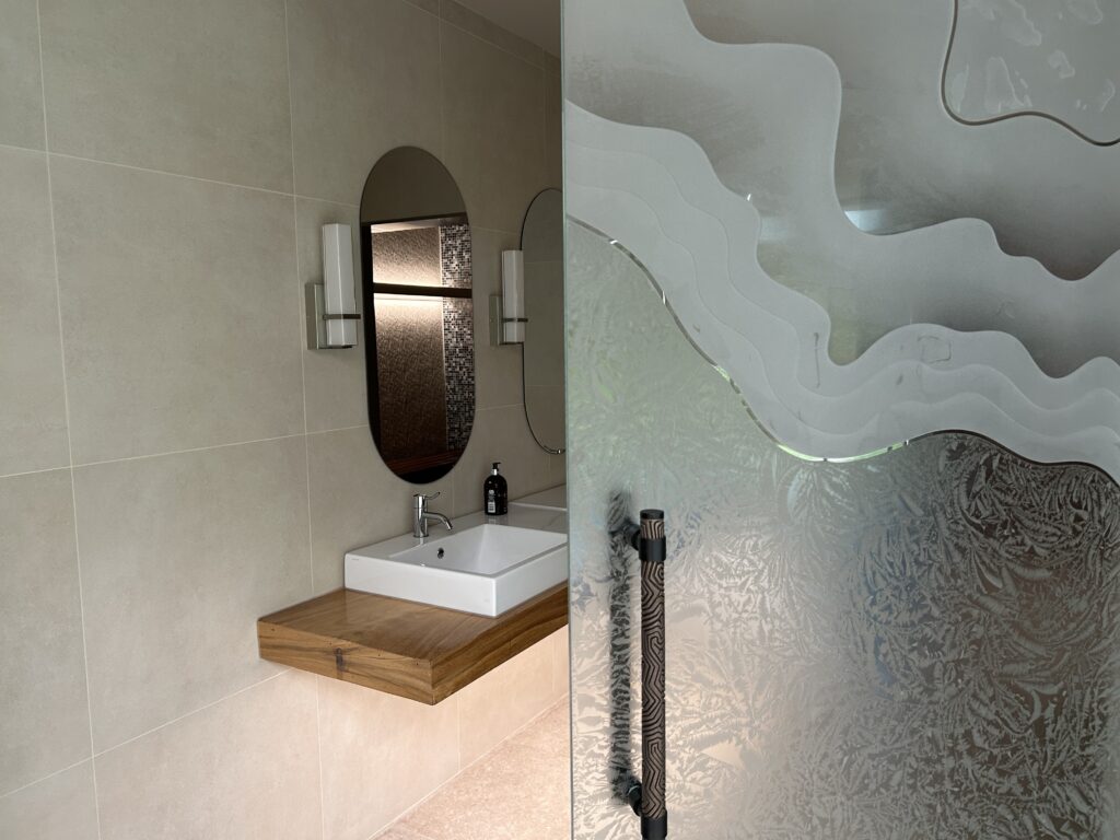 Close-up look of a modern frosted glass shower door with gluechip design