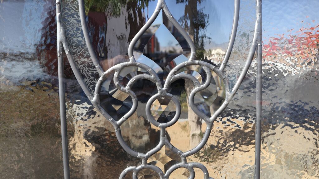 Close-up of front door privacy glass with leaded bevels, faceted jewel accents, and textured glass.