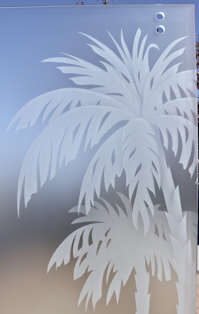 Detailed etched palm tree leaves on frosted privacy glass panel with soft gradient background