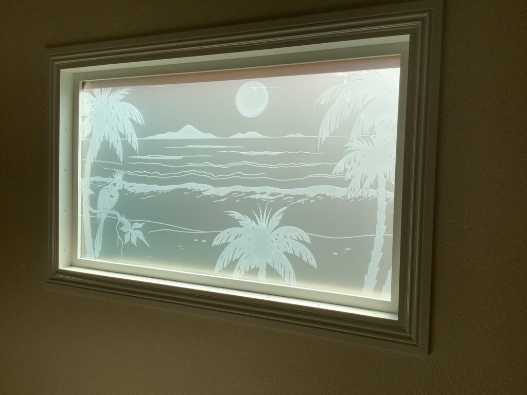 Compact bathroom window with artistic etched glass, perfect for small layouts needing more light.