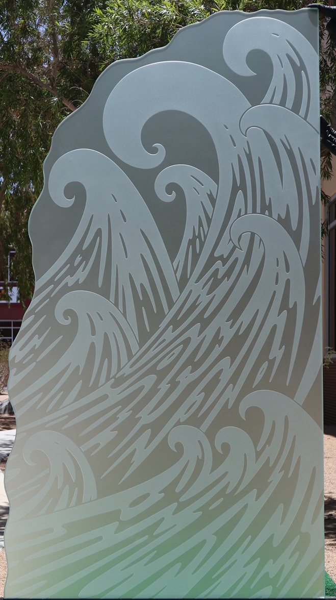 Close-up view of a frosted glass shower panel with etched wave design and chiseled edge, ideal for modern glass shower partitions.