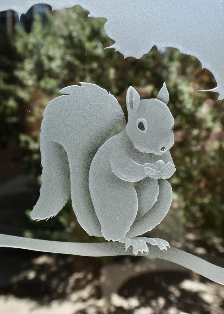 Frosted squirrel detail carved into a Woodland Scene decorative glass partition panel