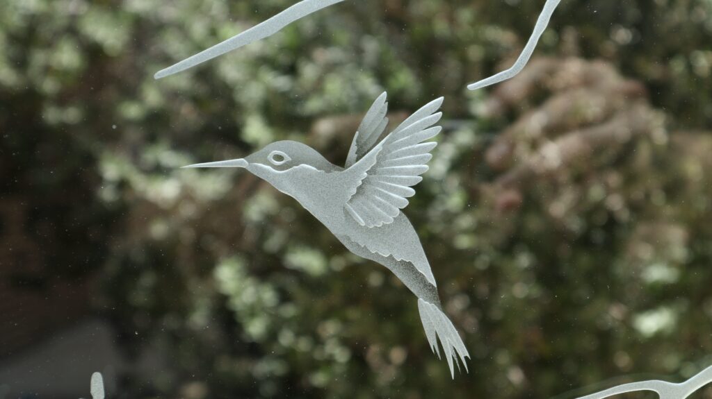 Frosted hummingbird detail in a Woodland Scene glass partition panel with wildlife design