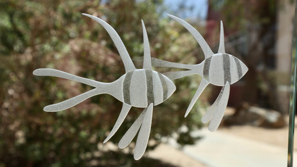 3D frosted glass design of two graceful fish swimming together, showcasing delicate details and smooth textures.