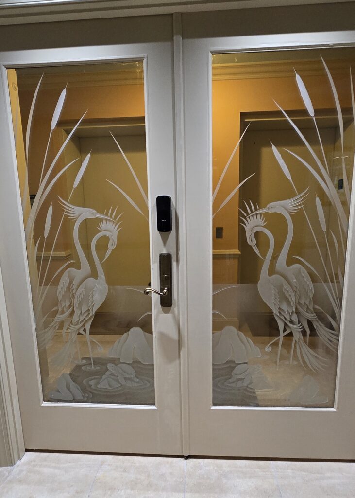 Front doors with frosted and carved glass crane design combining clear and frosted areas for layered privacy and visibility