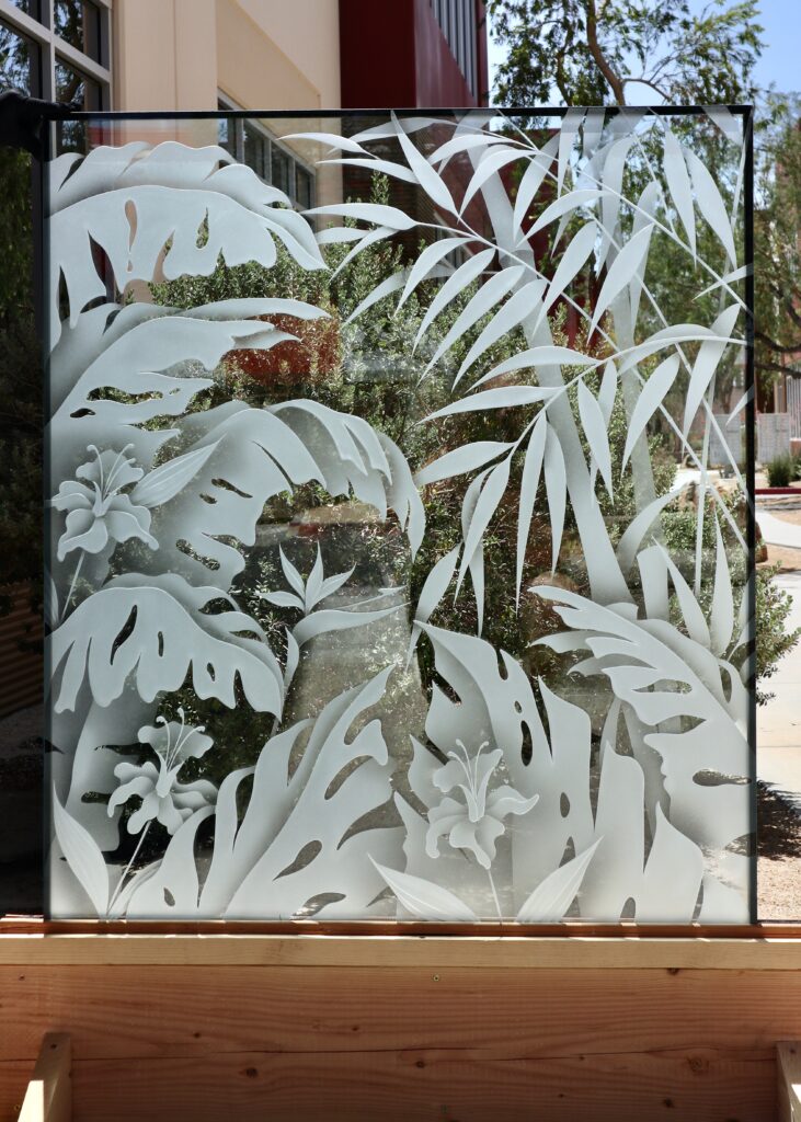 Custom tropical glass partition with carved bamboo, monstera leaves, flowers, and palm-inspired foliage for a personalized interior.