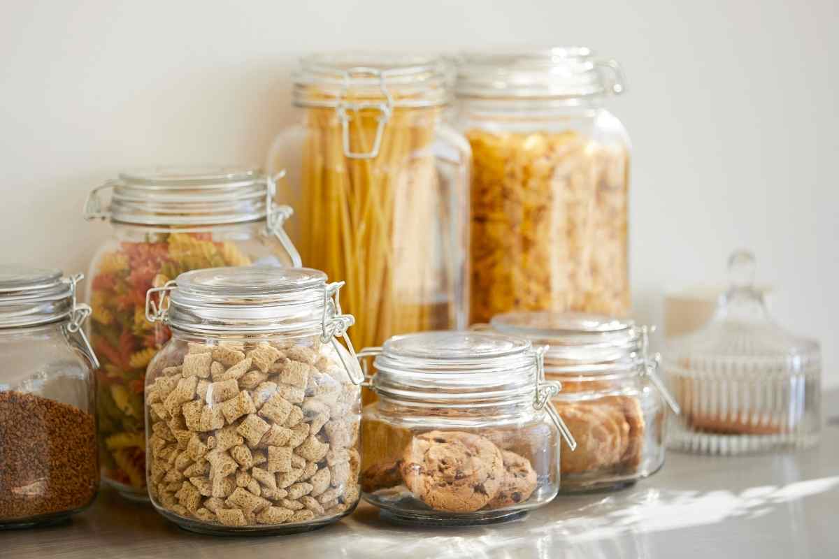 Airtight jars storing flour, rice, and pasta as practical small kitchen pantry ideas.