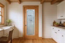 Farmhouse pantry door with Bread Basket frosted glass design in a cozy rustic kitchen setting.