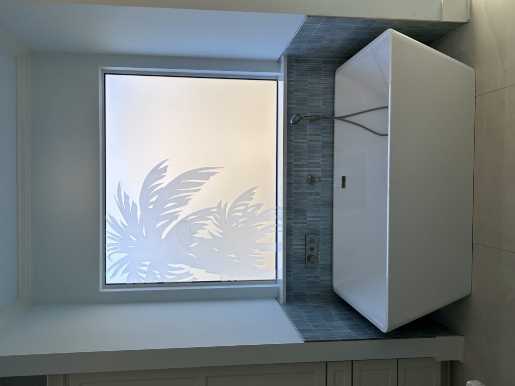 Privacy frosted glass window installed above a modern white bathtub