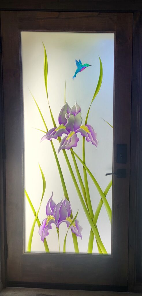 Front door with decorative glass iris flowers and hummingbird design, combining color, frosted glass, privacy, and artistry