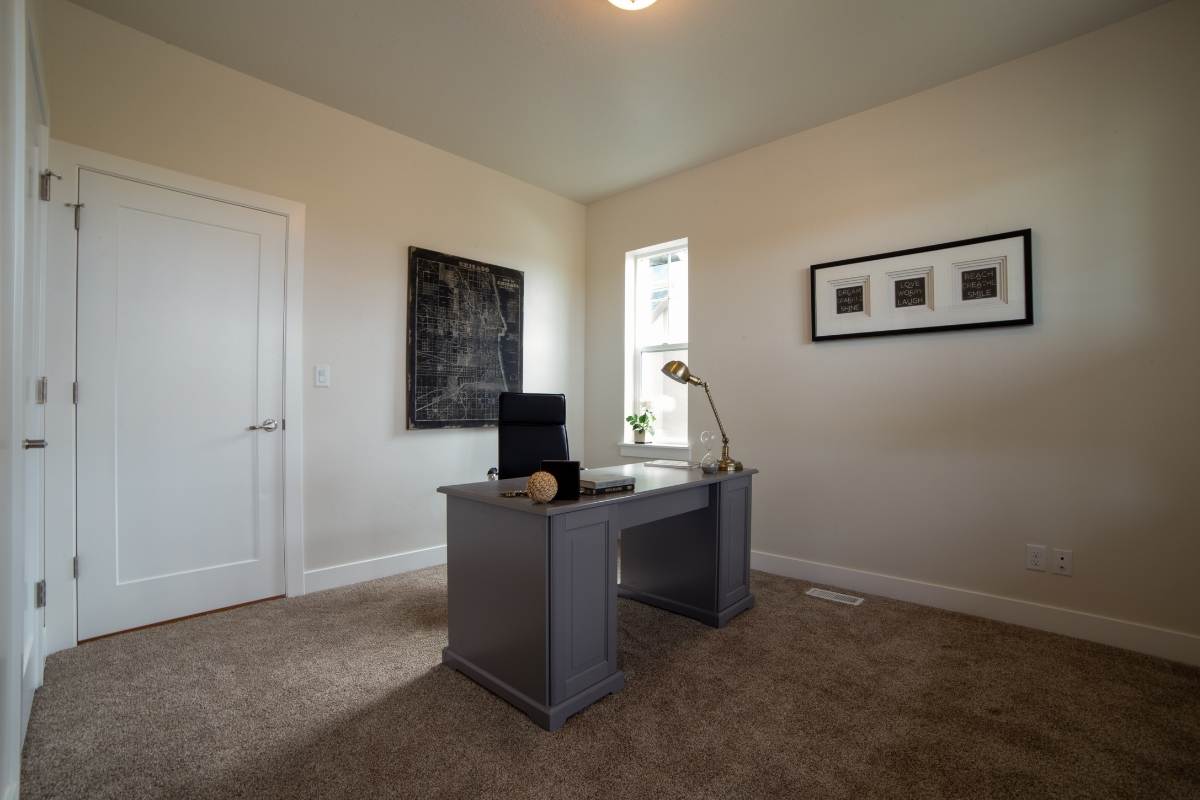 Minimal home office with white solid core interior door and desk centered in a neutral room