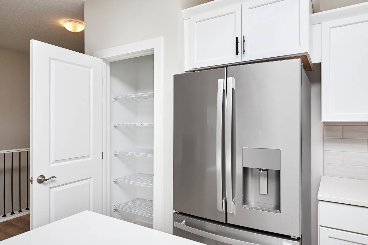 Pantry in the modern kitchen with classic wood panel pantry door