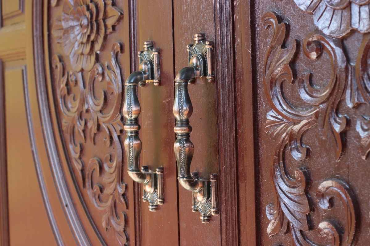 Carved wood double doors with ornate handles, luxury statement entry door design