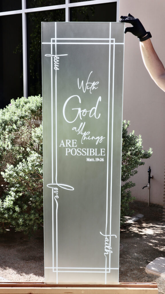 Custom frosted glass panel with inspirational lettering and decorative etched borders, demonstrating Sans Soucie's expertise in personalized sandblasted glass and custom etched artwork