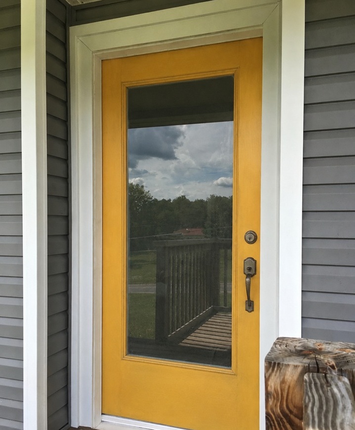 Old worn glass front door before being updated with a decorative hibiscus and hummingbird glass design.