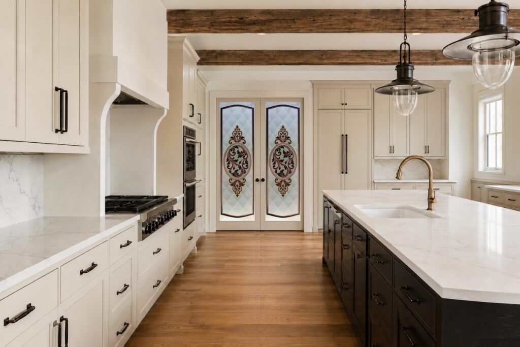 Double frosted glass pantry doors with ornate painted filigree design in a modern farmhouse kitchen