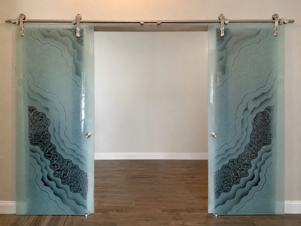 Custom double barn doors with carved frosted glass featuring mirrored abstract artwork and handcrafted decorative glass panels.
